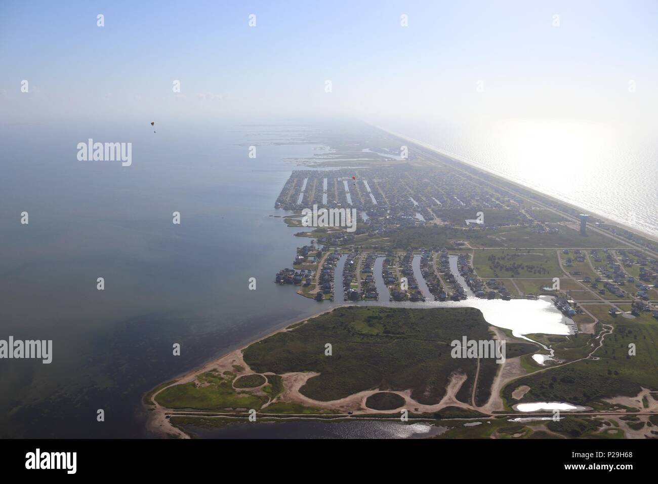 Vue aérienne de la côte du golfe du Texas, Galveston Island, USA. Haze en raison de conditions climatiques chaudes. Deux pilotes de paramoteur, l'immobilier et les paysages. Banque D'Images