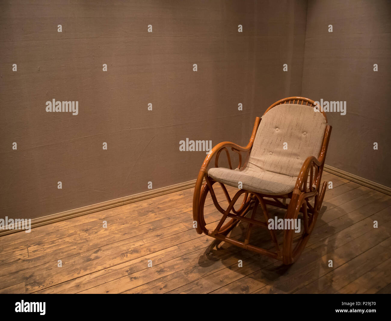 Fauteuil à bascule en osier dans la salle vide avec plancher en bois, concept piscine composition Banque D'Images