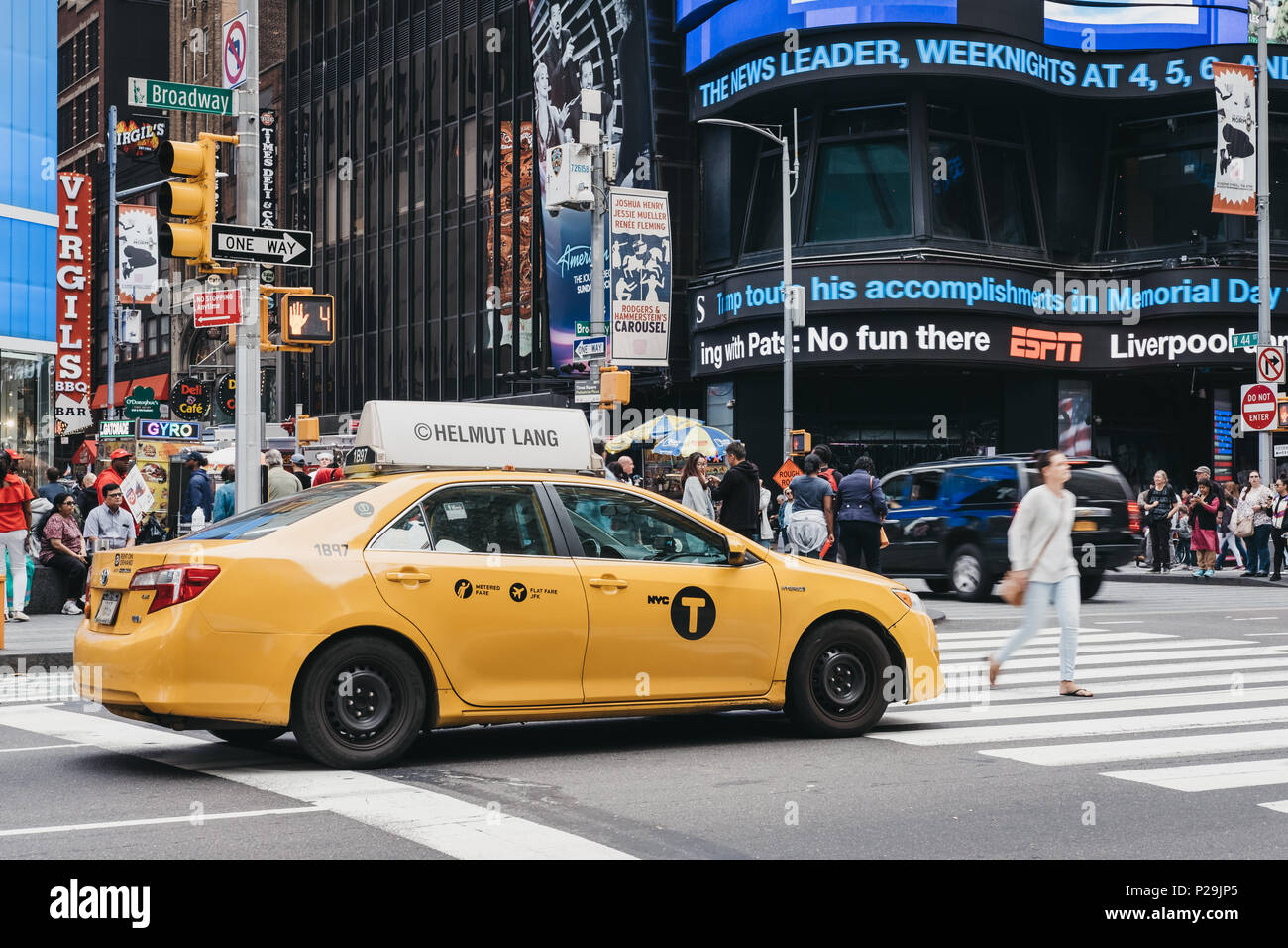Taxi jaune en attente sur le feu à New York, les piétons qui traversent en face d'elle. Banque D'Images