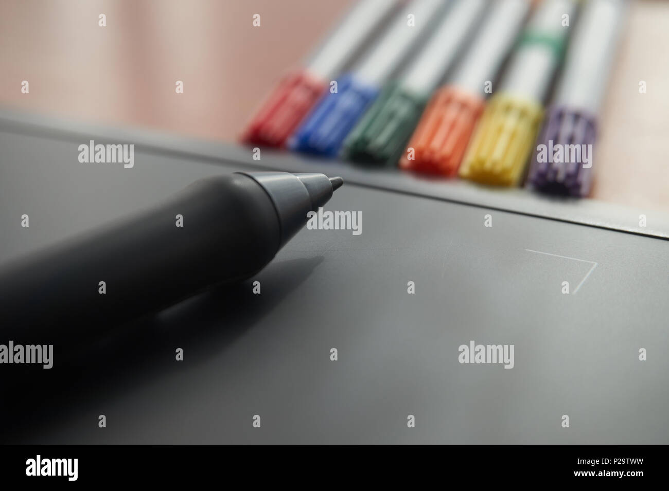 Stylet sur tablette graphique avec les marqueurs de couleur en arrière-plan Banque D'Images