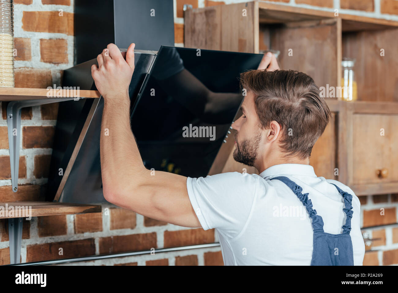 Close-up view of handsome handyman fixing hotte Banque D'Images