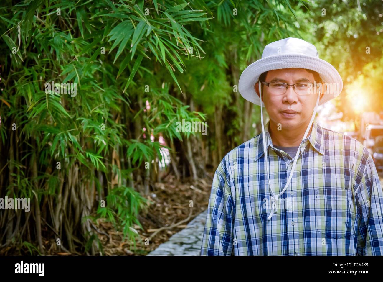 40-55 ans homme agriculteur réussi. Carrière croissante de bambou. Une carrière qui peut être extrêmement dures de revenu. En utilisant le modèle d'entreprise agricole à puce. Banque D'Images