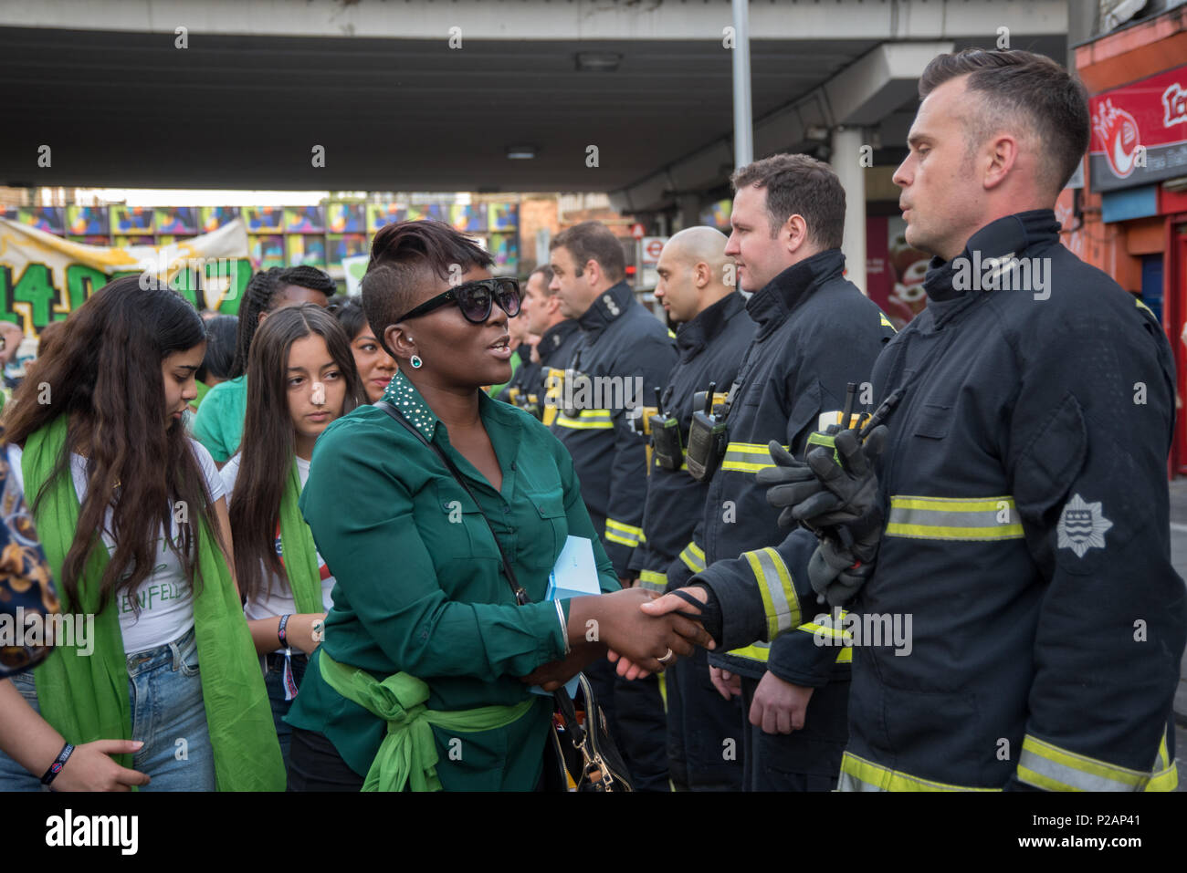 Londres, Royaume-Uni. 14 juin 2018. Les gens concubinage la main avec les pompiers de la marche silencieuse de Grenfell - 1 an sur pour marquer l'anniversaire de l'incendie de la tour de Grenfell, demander justice pour Grenfell le 14 juin 2018, Londres, Royaume-Uni. Credit : Voir Li/Alamy Live News Banque D'Images