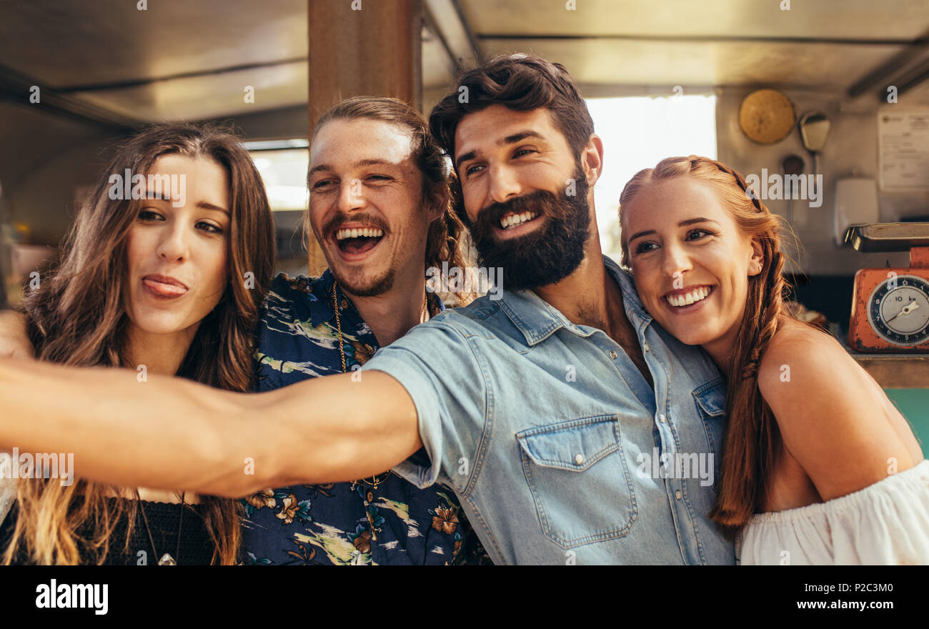 Heureux jeune mec avec des amis en prenant un. selfies Groupe d'amis à l'extérieur. selfies Banque D'Images