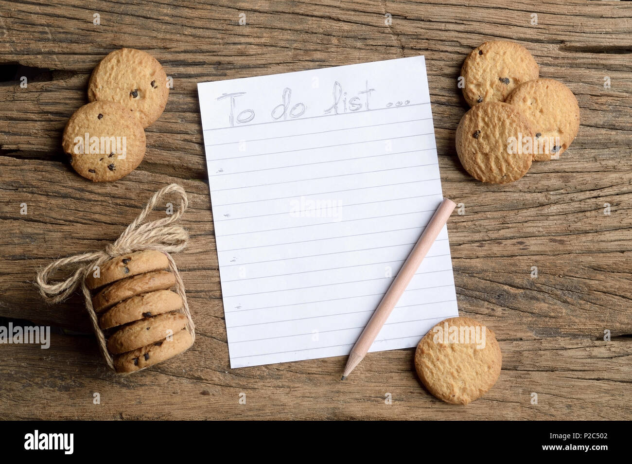 Écrire pour faire la liste sur table en bois avec biscuit aux brisures de chocolat Banque D'Images