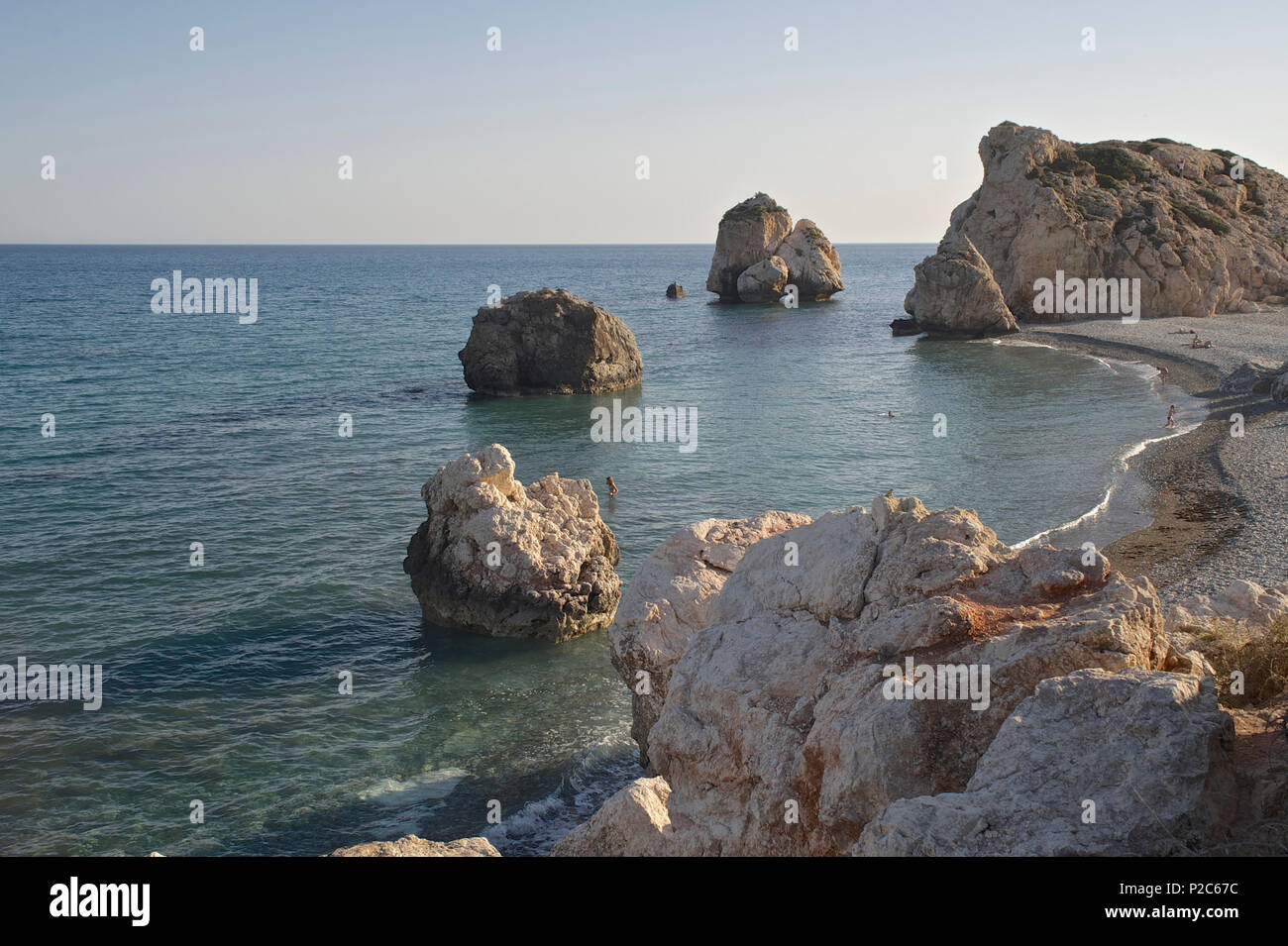 Plage de galets et les gens se baigner dans la mer à Petra tou Romiou, Aphrodites rock, Paphos, Chypre Banque D'Images