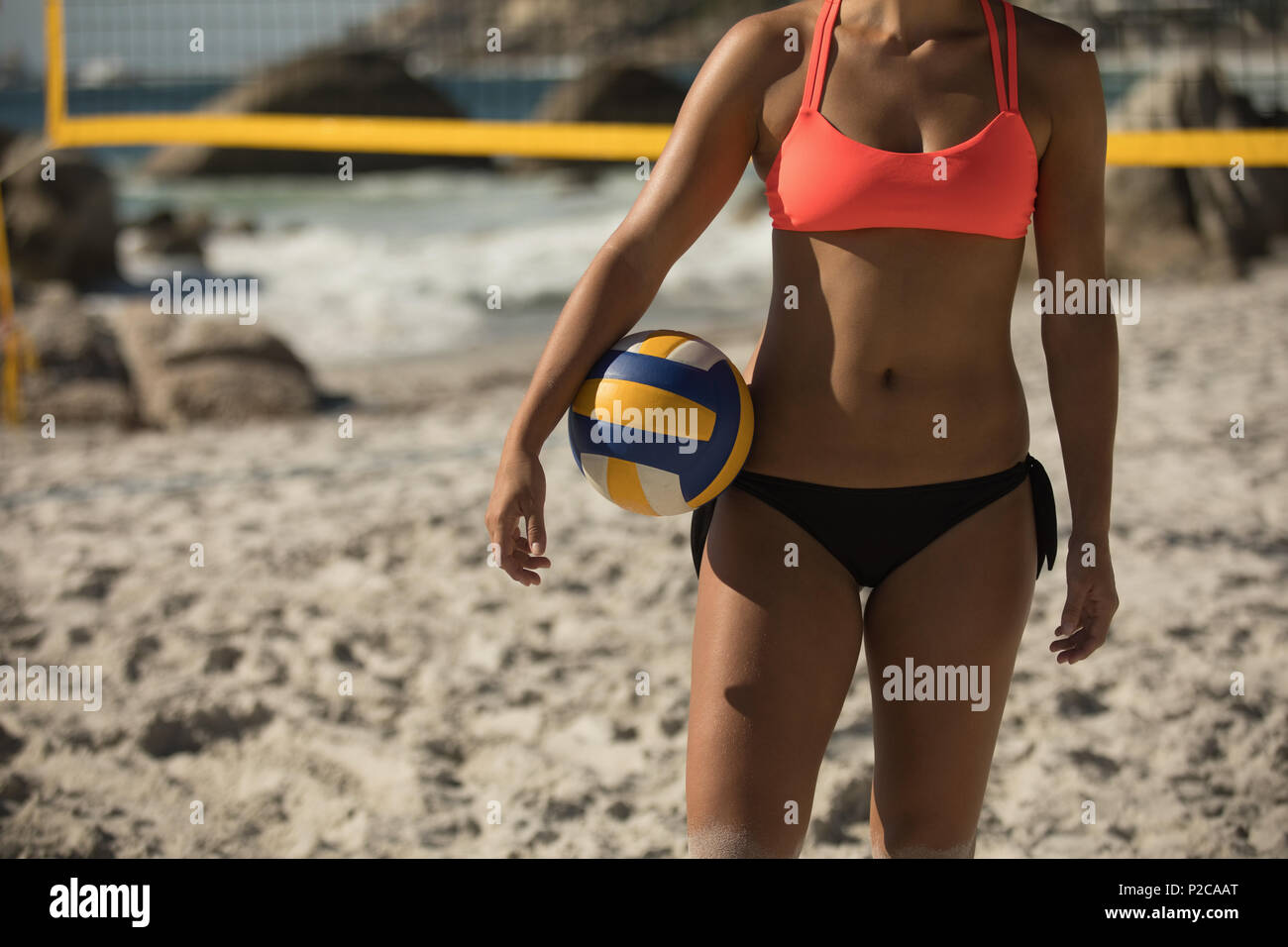 Joueur de volley-ball féminin de volley-ball debout sur la plage Banque D'Images