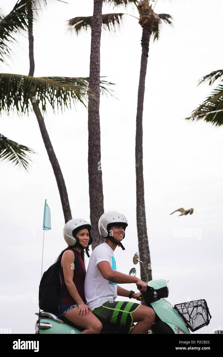 Couple riding scooter dans la ville Banque D'Images