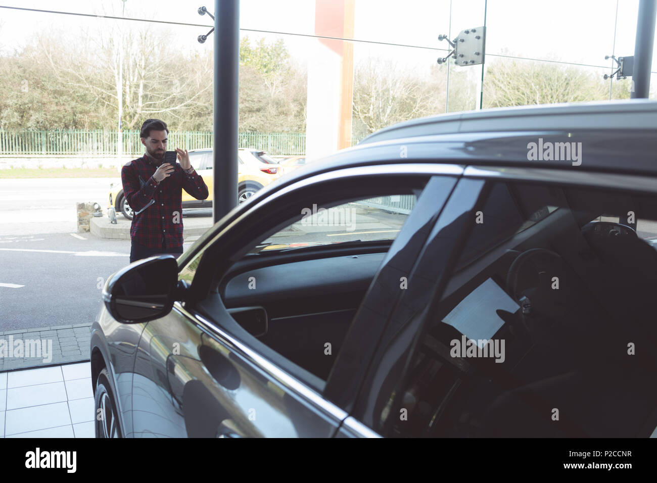 Vendeur de prendre photo de voiture avec un téléphone mobile Banque D'Images