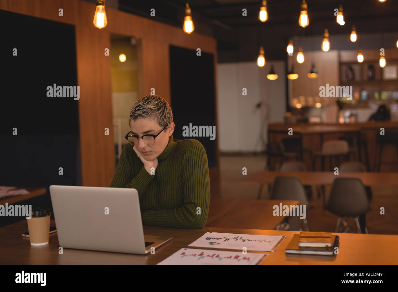 Businesswoman using laptop in cafeteria Banque D'Images