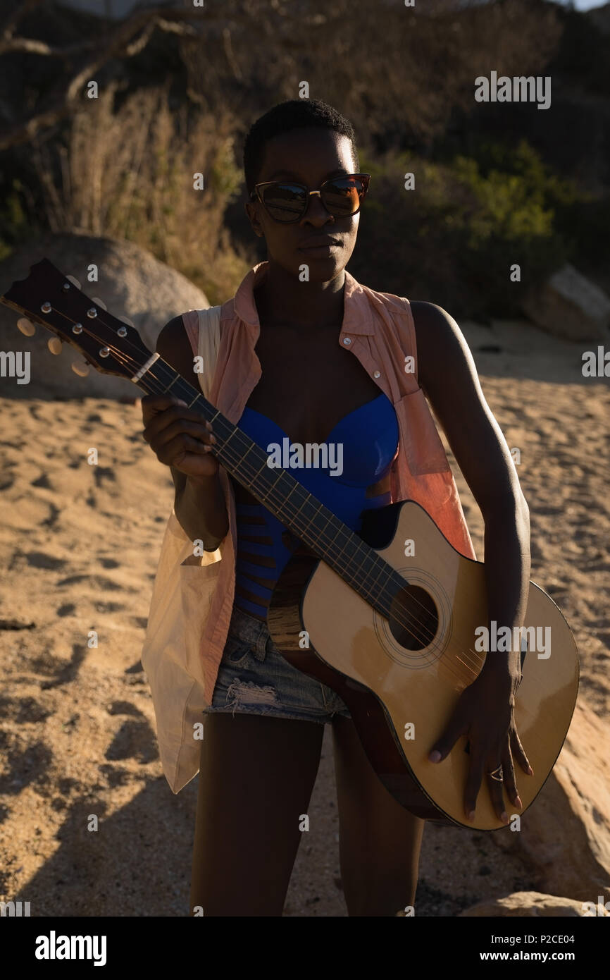 Femme tenant la guitare dans la plage Banque D'Images