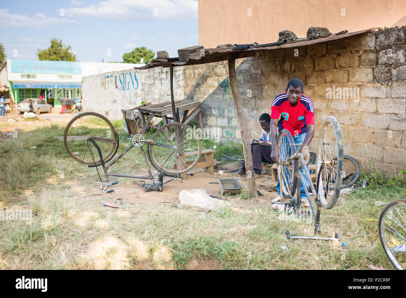 Réparations homme vélos dans petite ville village de Mumbwa, la Zambie sur la Great West Road. La ville est un dépôt d'approvisionnement pour la région qui comprend de la Kafue. Banque D'Images
