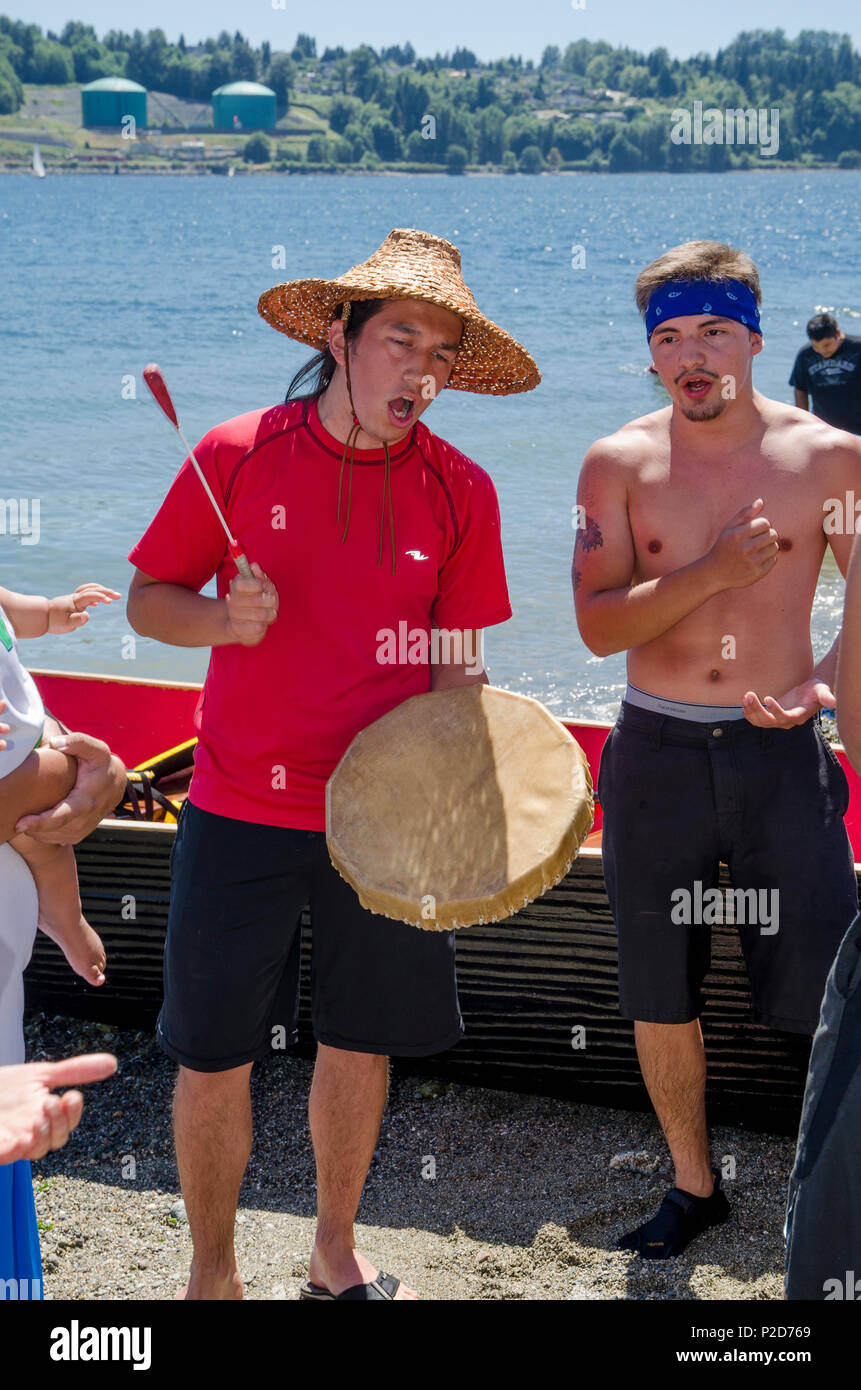 Un Sḵwx̱wú Khelsilem,7mesh-Kwakwa̱ka̱'wakw artiste éducateur à tambour bat le rassemblement estival de la mer des Salish, 2013 Whey-Ah-Wichen (Cates Park) N. Vancouver, B Banque D'Images