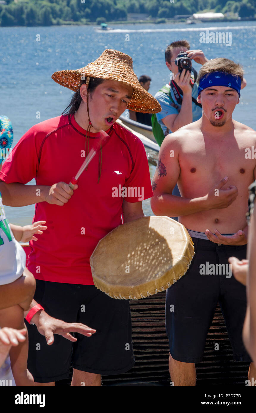 Un Sḵwx̱wú Khelsilem,7mesh-Kwakwa̱ka̱'wakw artiste éducateur à tambour bat le rassemblement estival de la mer des Salish, 2013 Whey-Ah-Wichen (Cates Park) N. Vancouver, B Banque D'Images