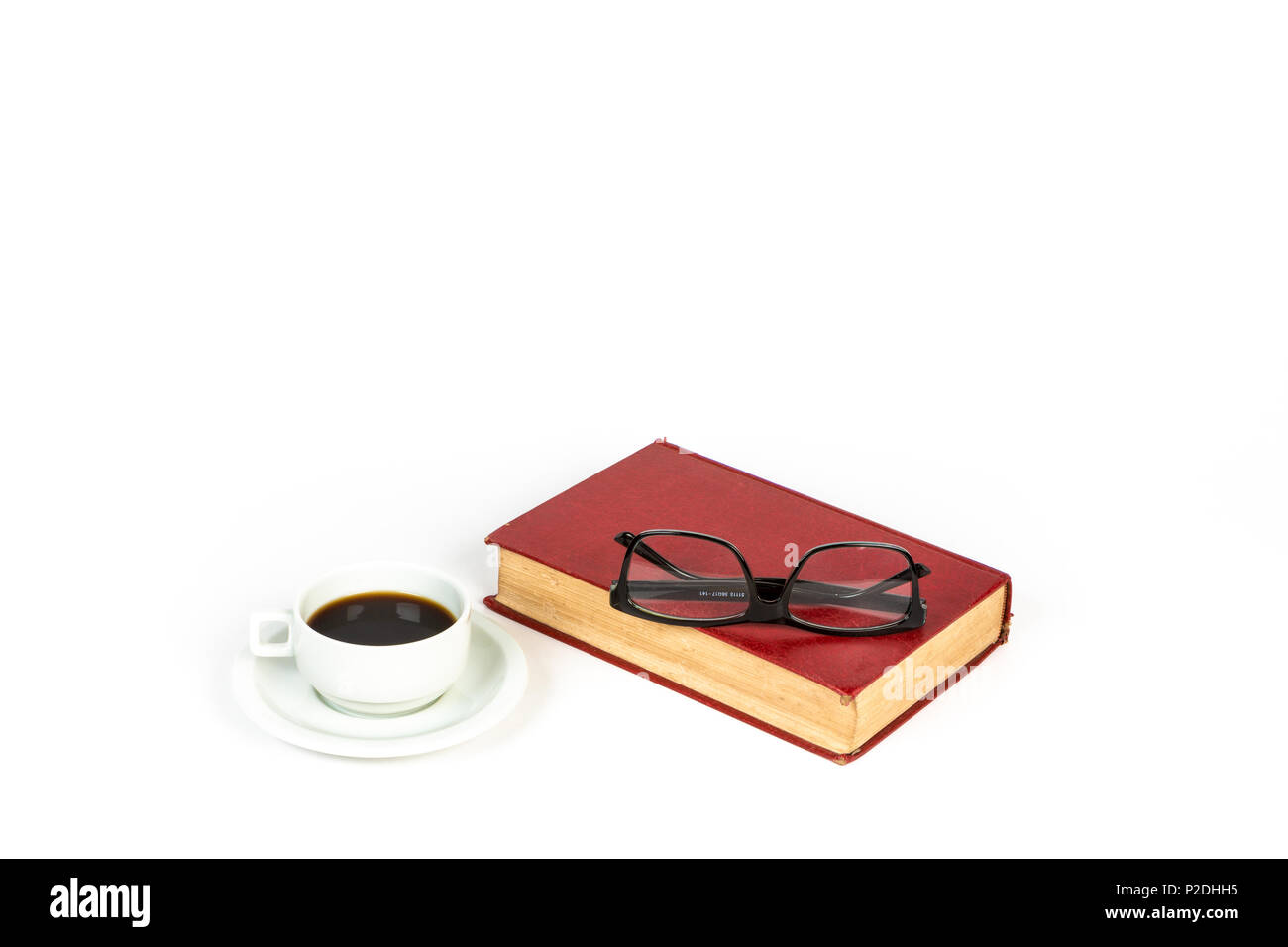 Un livre vintage rouge, une tasse de café, et lunettes noires sur fond blanc. Banque D'Images