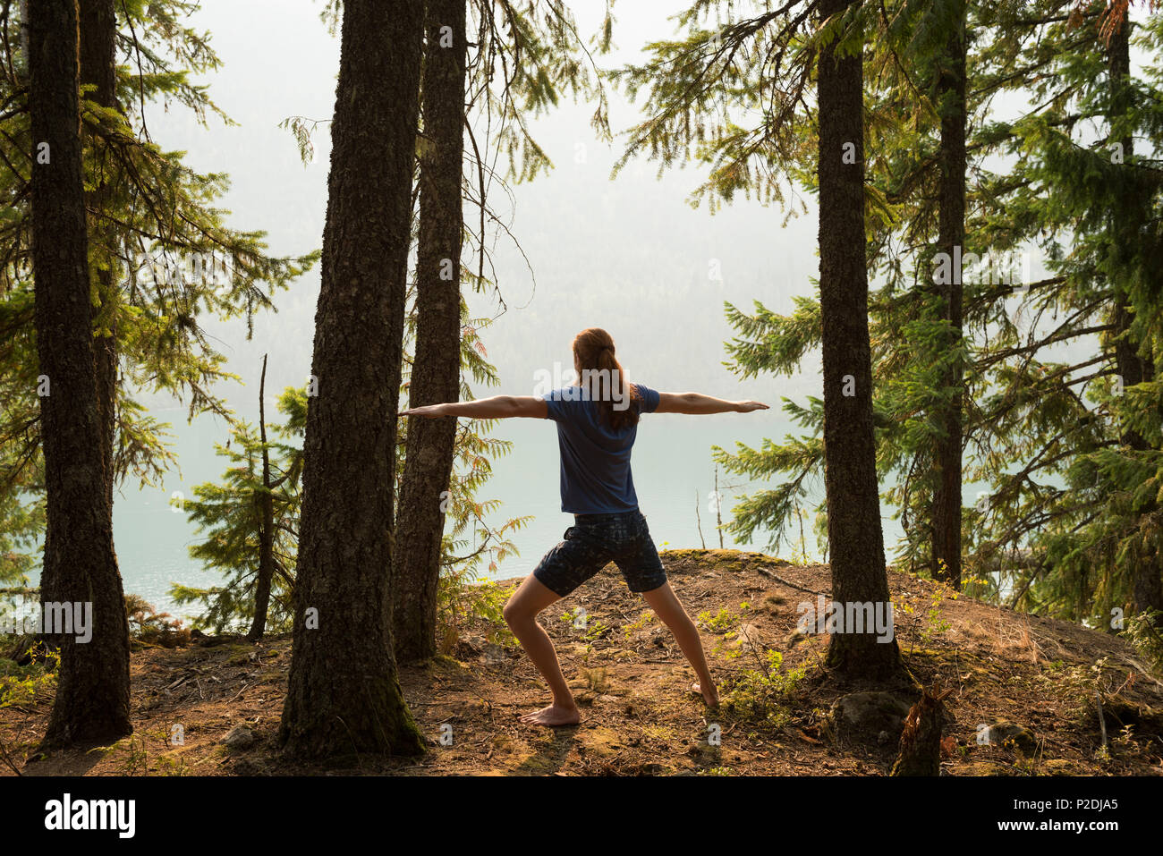Fit man performing exercice s'étendant dans une luxuriante forêt verte Banque D'Images