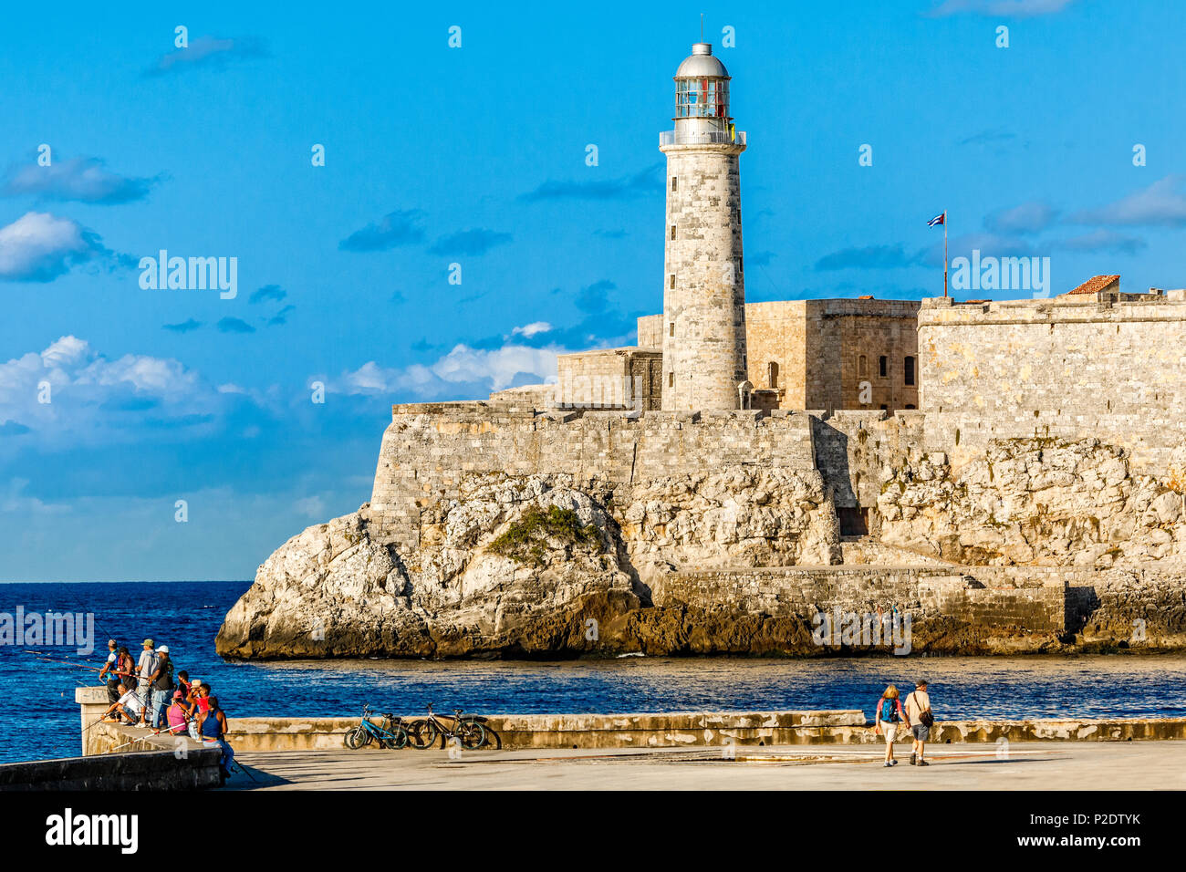 El Morro forteresse espagnole des murs avec phare, à quelques personnes et les pêcheurs à l'avant-plan, La Havane, Cuba Banque D'Images