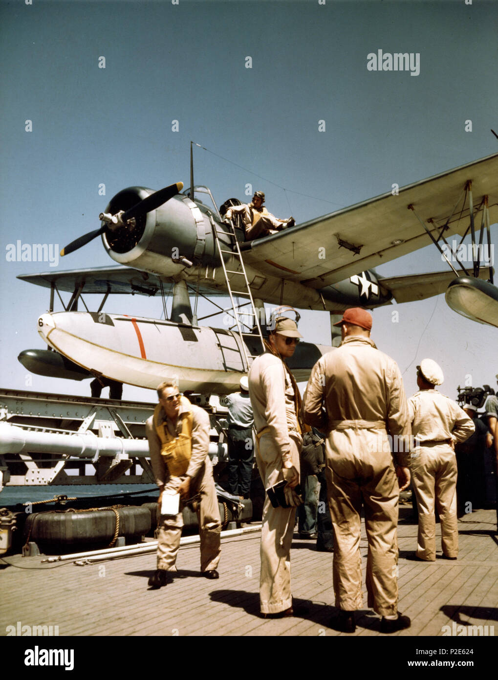 . Le pilote d'un Vought OS2U Kingfisher hydravion à unstraps son vol historique à partir du sa jambe, après son retour d'un vol pour cuirassé de la Marine américaine USS Missouri (BB-63). L'avion est sur la catapulte derrière lui. Les photgraph a été prise au cours de la période de rodage du Missouri, à l'été 1944. L'été 1944. La NSU 39 OS2U USS Missouri sur pilote (BB-63) en 1944 Banque D'Images