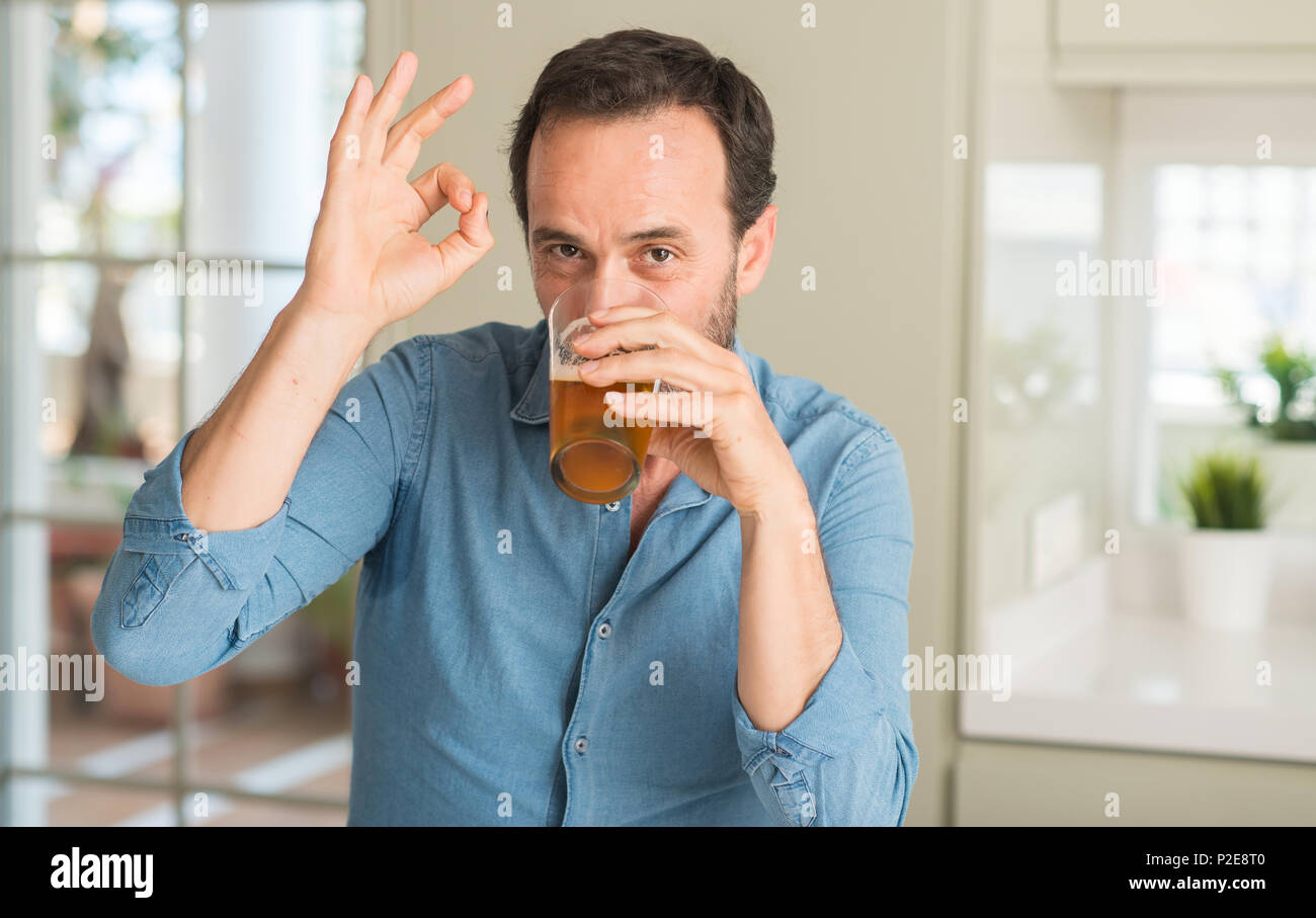 L'âge moyen man drinking beer faire ok signe avec les doigts, symbole excellent Photo Stock Alamy