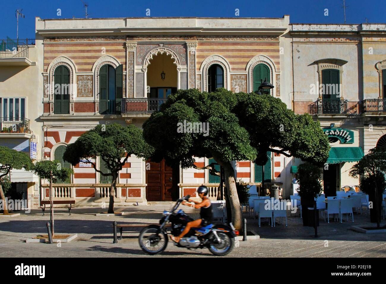 Italie, Pouilles, Peninsule du Salteno, Biker en passant en face d'un bâtiment de style néo byzantin Banque D'Images