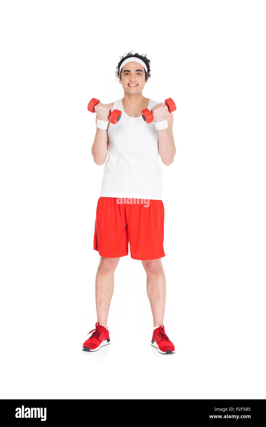 Jeune homme mince en sportswear holding dumbbells isolated on white Banque D'Images