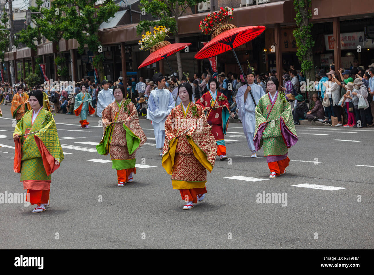 Les femmes en costume traditionnel avec un grand parapluie rouge au cours Festival Aoi Matsuri à Kyoto, Japon Banque D'Images