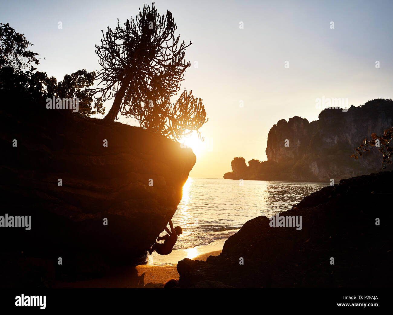 Rock climber en silhouette à Tonsai beach au coucher du soleil à Krabi, Thaïlande Banque D'Images