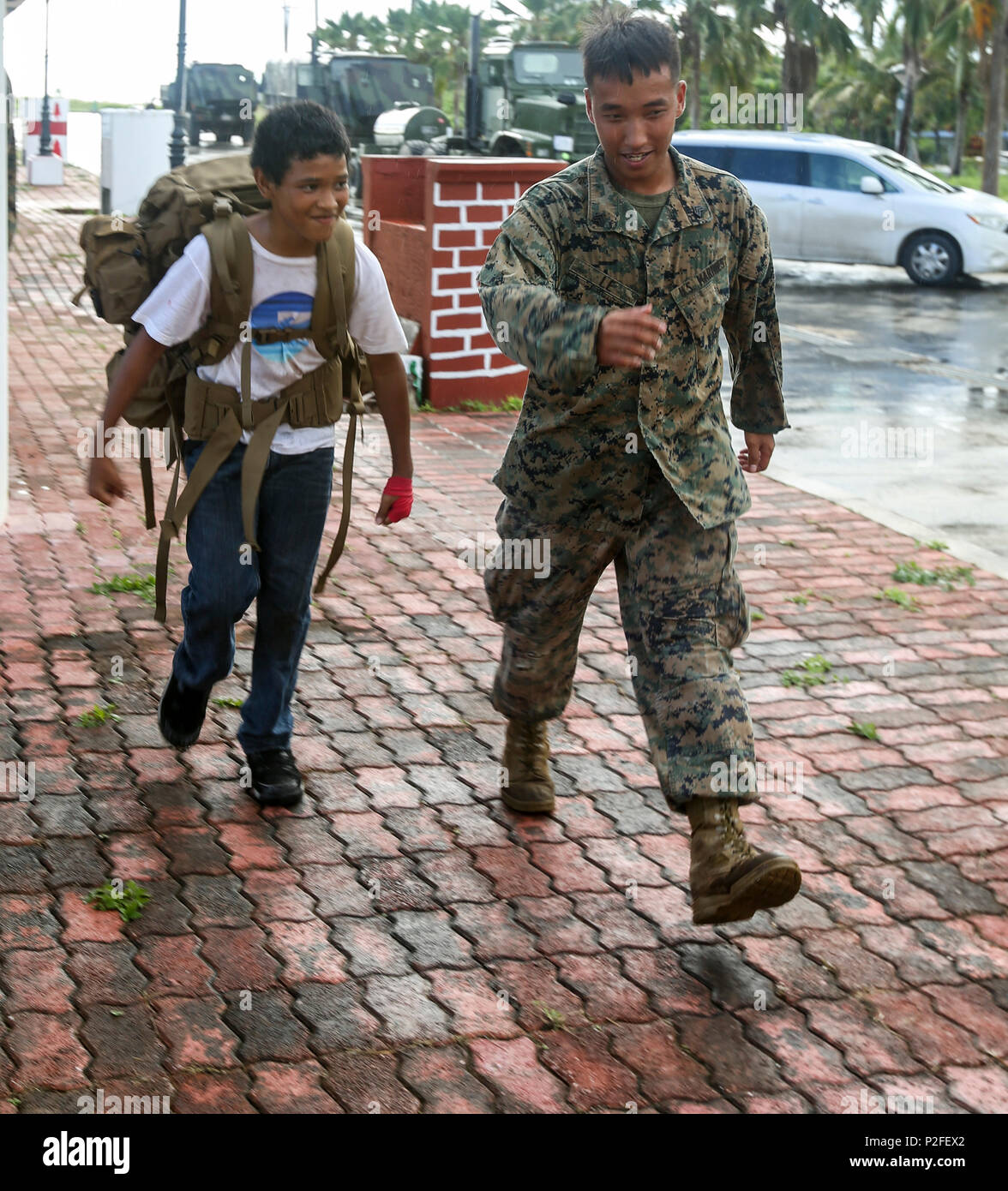 Le sergent du Corps des Marines américain Hung Le superviseur d'une radio  avec aile Marine 18 e Escadron des communications, borde un local de Tinian  pour démontrer le poids que portent les