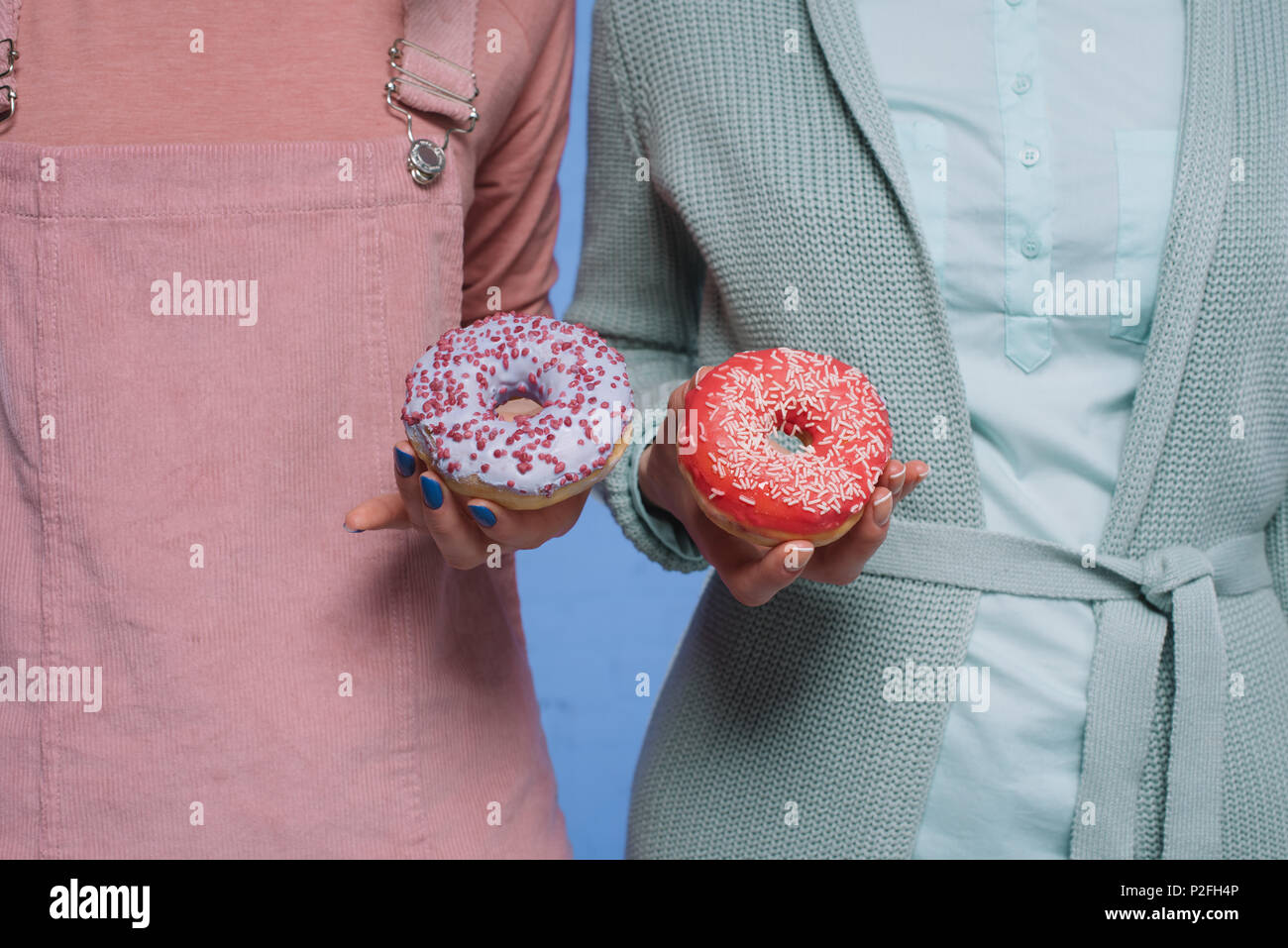 Cropped shot of women holding donuts glacé Banque D'Images