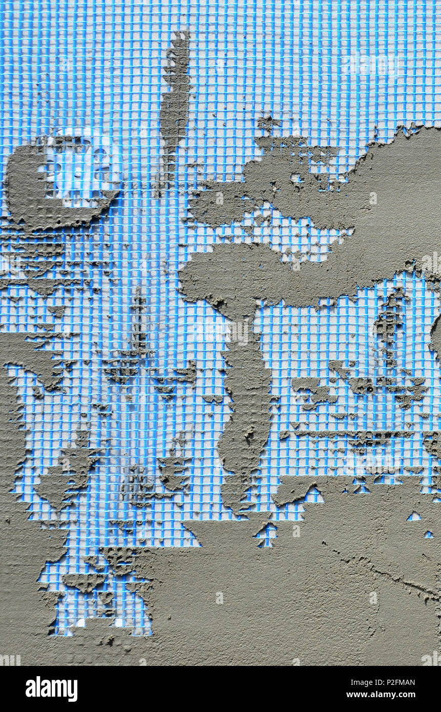 La texture du mur, recouvert de plaques de polystyrène mousse gris, recouvert d'un treillis d'armature bleu et recouvert d'un mélange de collage. Sta Banque D'Images