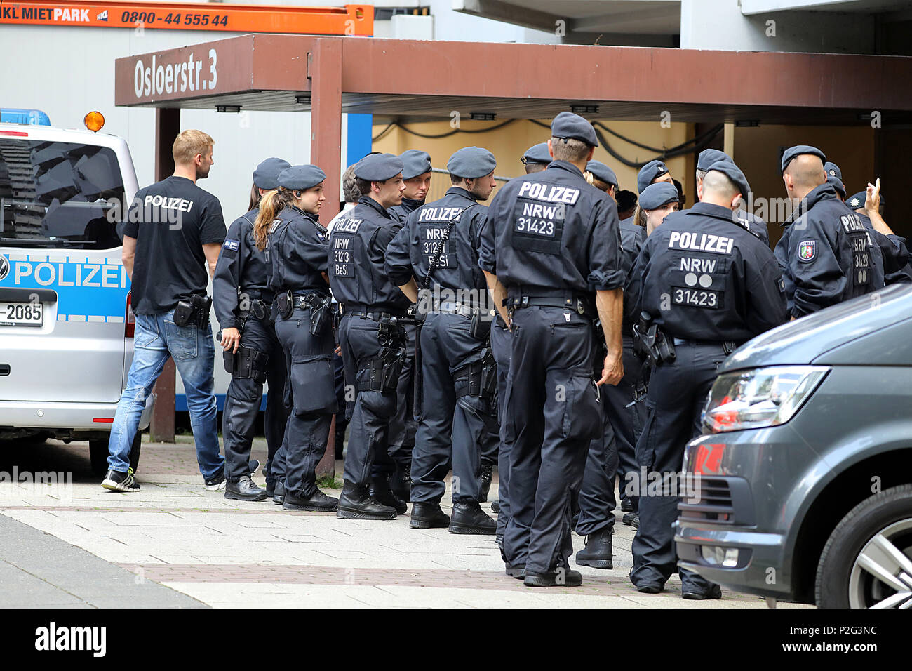 15 juin 2018, l'Allemagne, Cologne : policiers, debout devant l'immeuble d'habitation Osloerstr. 3 à Cologne-Chorweiler. La police est à la recherche de vendredi matin, à travers plusieurs appartements vidés dans le bâtiment après la ricine a été hautement toxiques qui s'y trouvent. Photo : Oliver Berg/dpa Banque D'Images