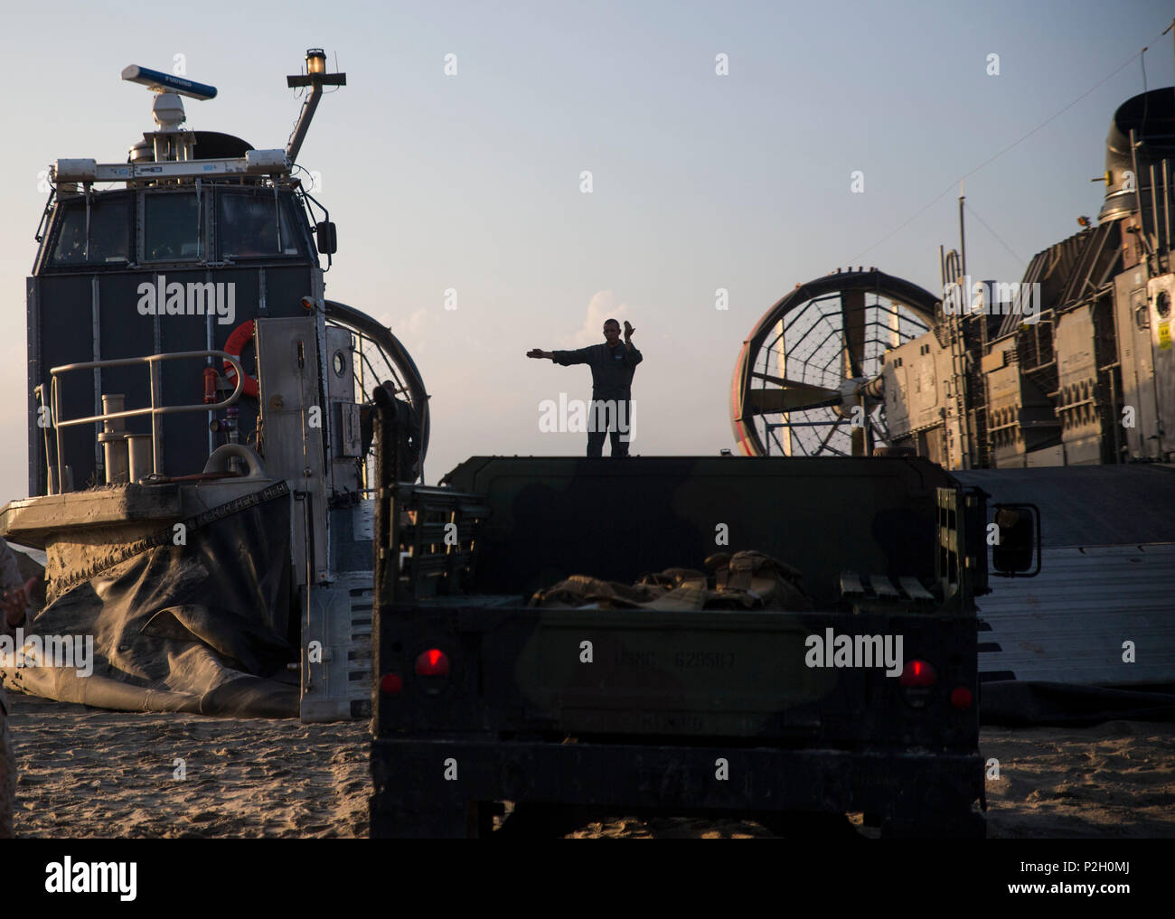 Un marin avec Beach Master Unit 1 dirige une Humvee pilote sur un bateau de débarquement véhicule à coussin d'air avec 4 unité d'assaut embarquée à bord de l'USS Bataan (LHD-5) au cours d'un déploiement du navire à la terre dans le cadre de leur PHIBRON/MEU intégration formation à Onslow Beach, North Carolina, 16 septembre 2016. Au cours d'un navire à la côte, le navire quitte la LCAC de milles de la côte d'accoster et de transport Marines avec la 24e Marine Expeditionary Unit et leur équipement à bord du navire. PMINT vous aidera à s'accoutument marins se pour travailler et vivre avec leurs homologues de la Marine sur le navire, les préparer à Banque D'Images