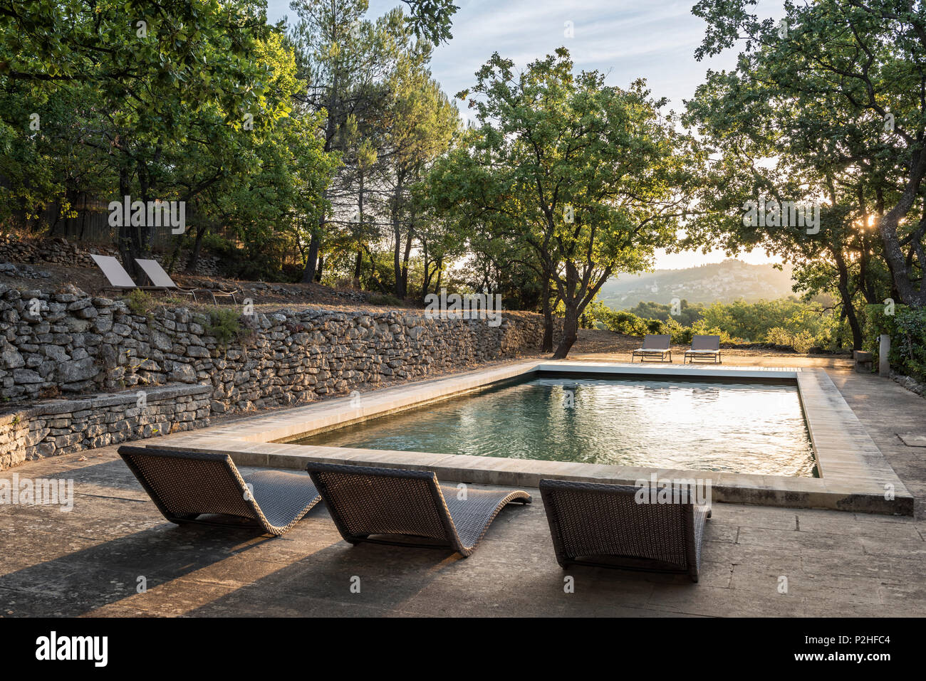 Chaises longues de la piscine dans un parc du Luberon ferme. Banque D'Images