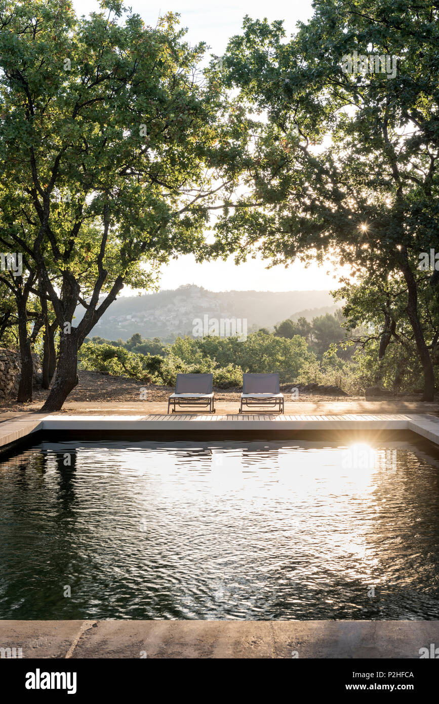 Chaises longues de la piscine dans un parc du Luberon ferme. Banque D'Images