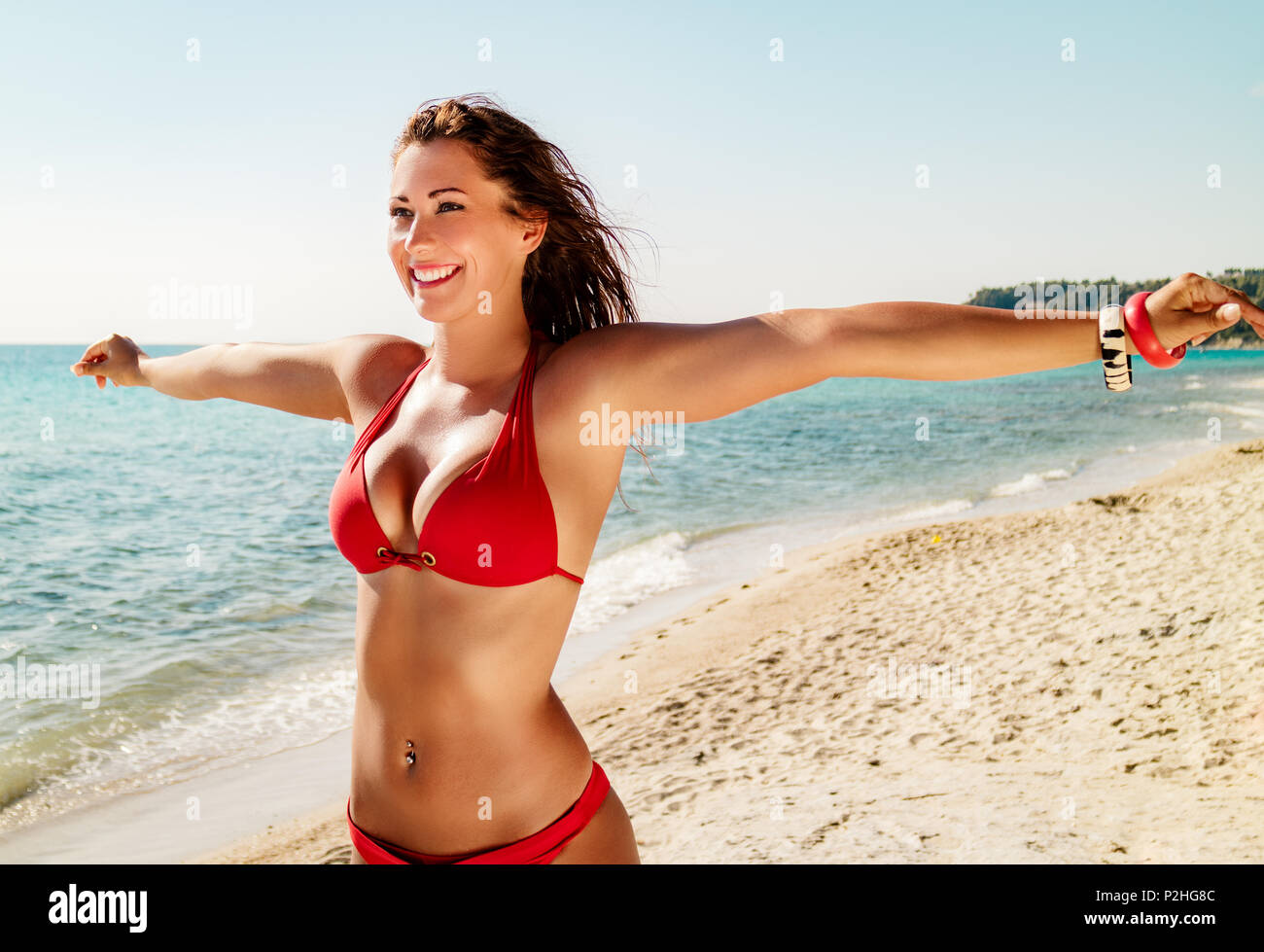 Belle jeune femme jouissant sur la plage à bras ouverts. Banque D'Images