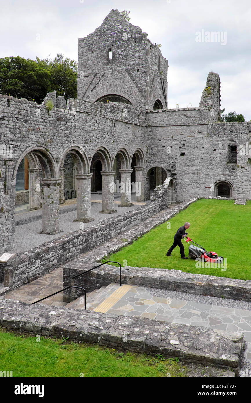 Un vieil homme / concierge / gardien tond la pelouse, l'abbaye de Boyle, Sycamore Crescent, Boyle, comté de Roscommon, Irlande Banque D'Images