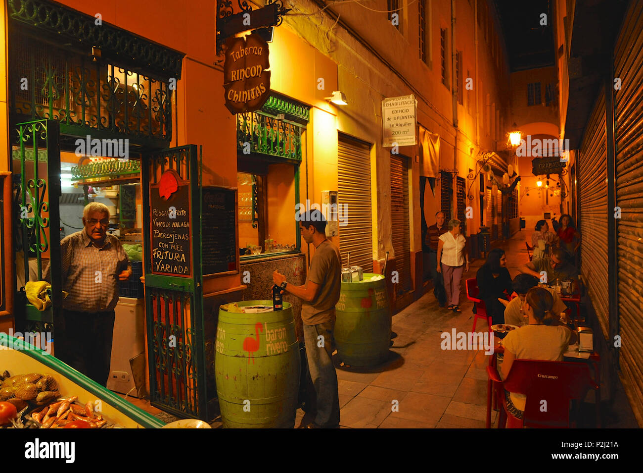 Petite route avec des poissons et des tables de restaurant près de la cathédrale de Malaga, dans la lumière du soir, Malaga, Andalousie, Espagne Banque D'Images