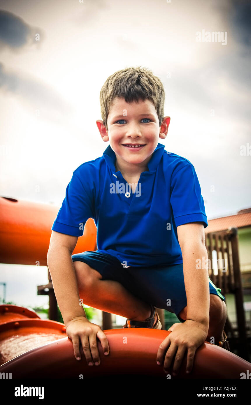 Heureux l'enfant dans l'aire de jeux indique que tout est ok avec la main Banque D'Images