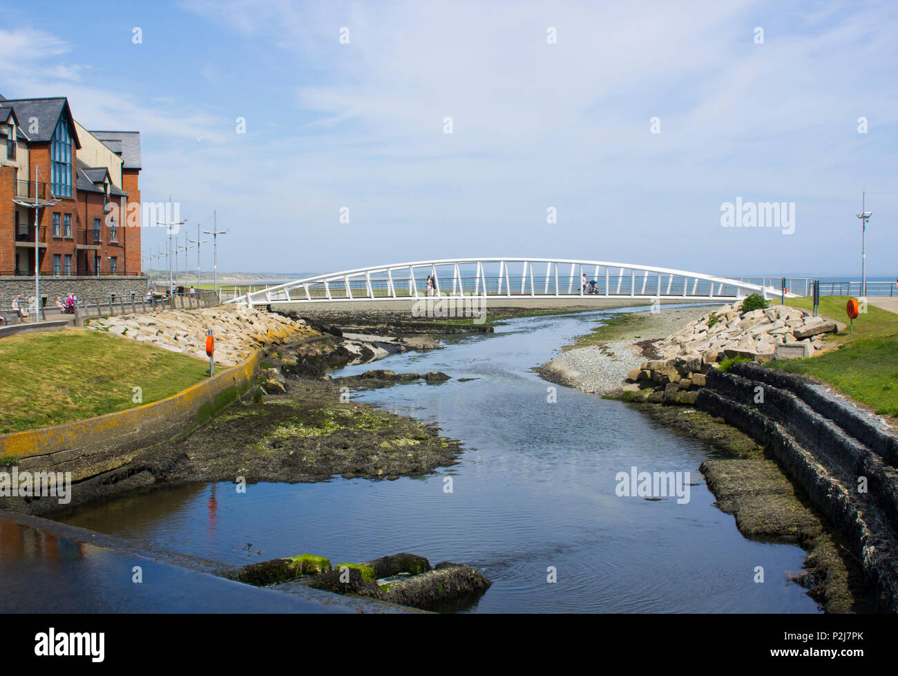 7 juin 2018 Les visiteurs qui traversent la passerelle moderne à l'embouchure de la rivière Shimna sur le front de mer dans le comté de Down en Irlande du Nord de Newcastle Banque D'Images