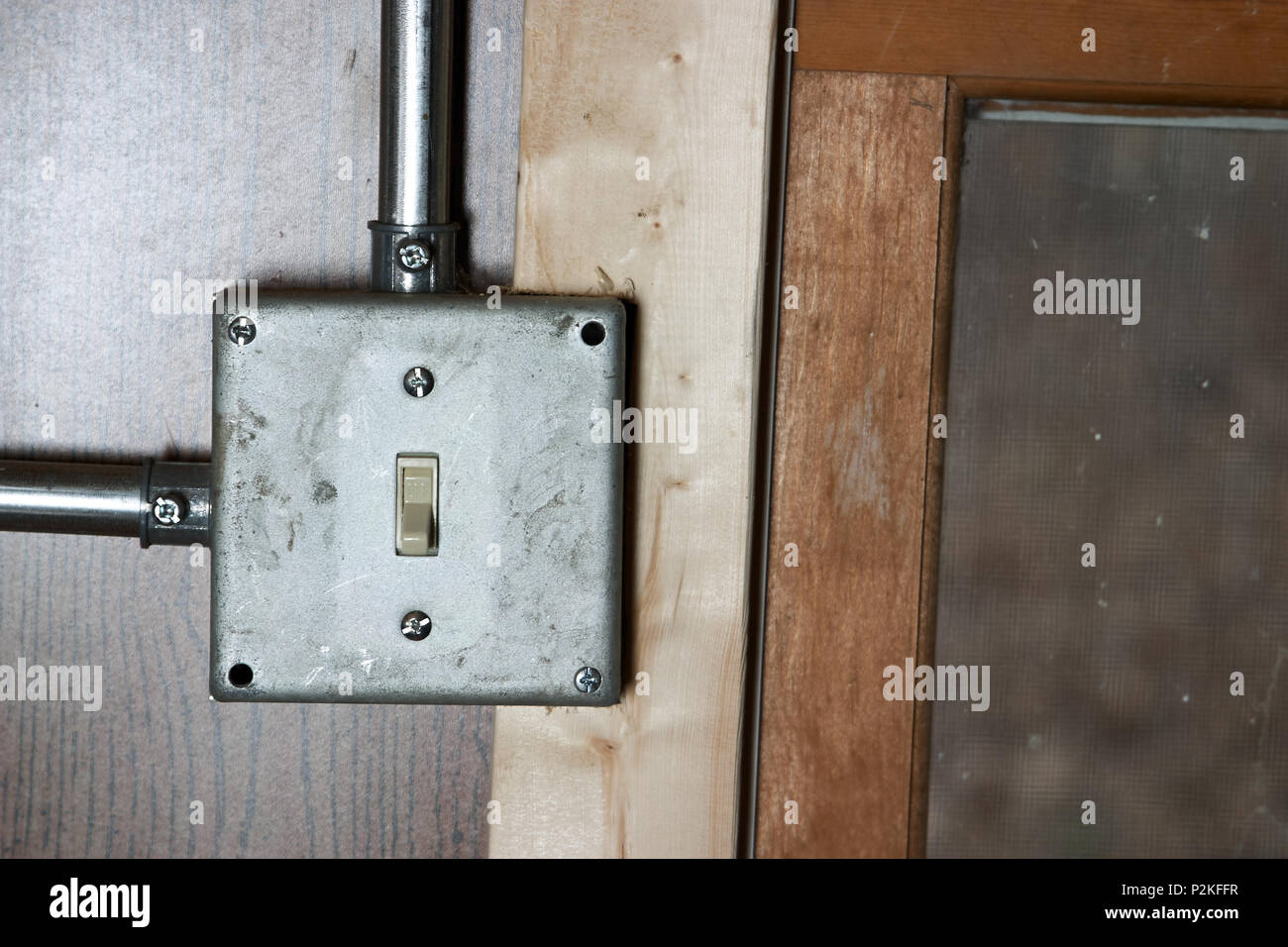 Old grunge metal montage de surface de l'interrupteur de l'électricité et le conduit d'échappement sur un panneau de bois dans une vue en gros plan conceptuel de la puissance et de l'énergie Banque D'Images