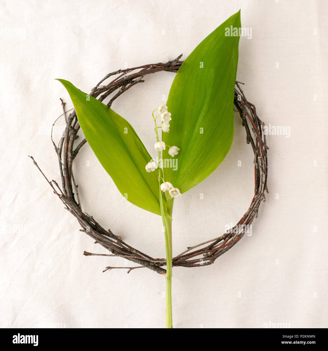 Composition florale. Couronne faite d'roools, feuilles, et de fleurs de muguet tissu sur fond blanc. Style rustique du décor à la maison, télévision, de laïcs Banque D'Images