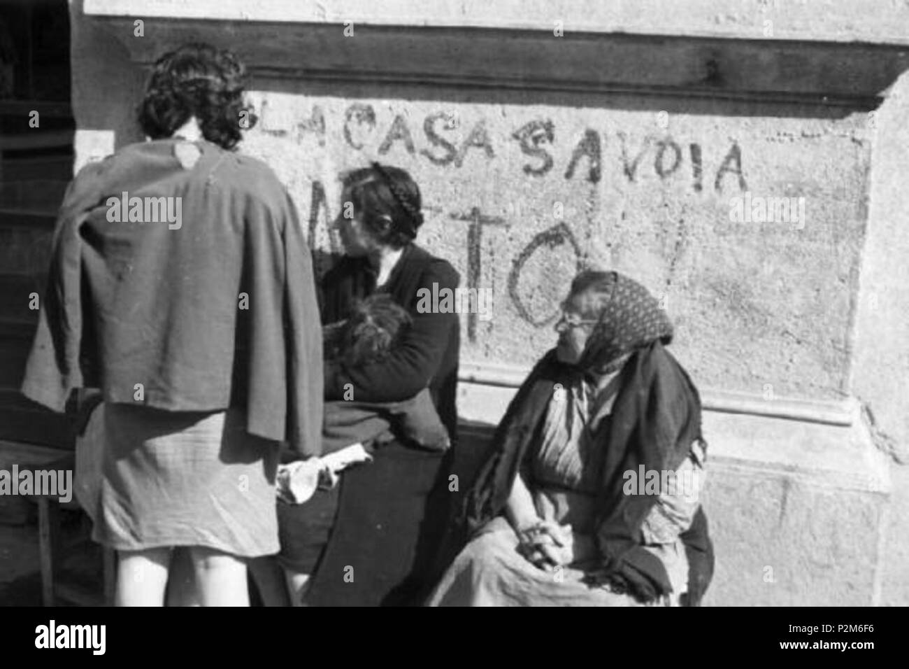 59 Napoli - Donne sedute in prossimità di un muro inneggiante alla Casa Savoia, 1946 (Naples, Italie, après la Seconde Guerre mondiale, les femmes, mur, Maison de Savoie) Banque D'Images