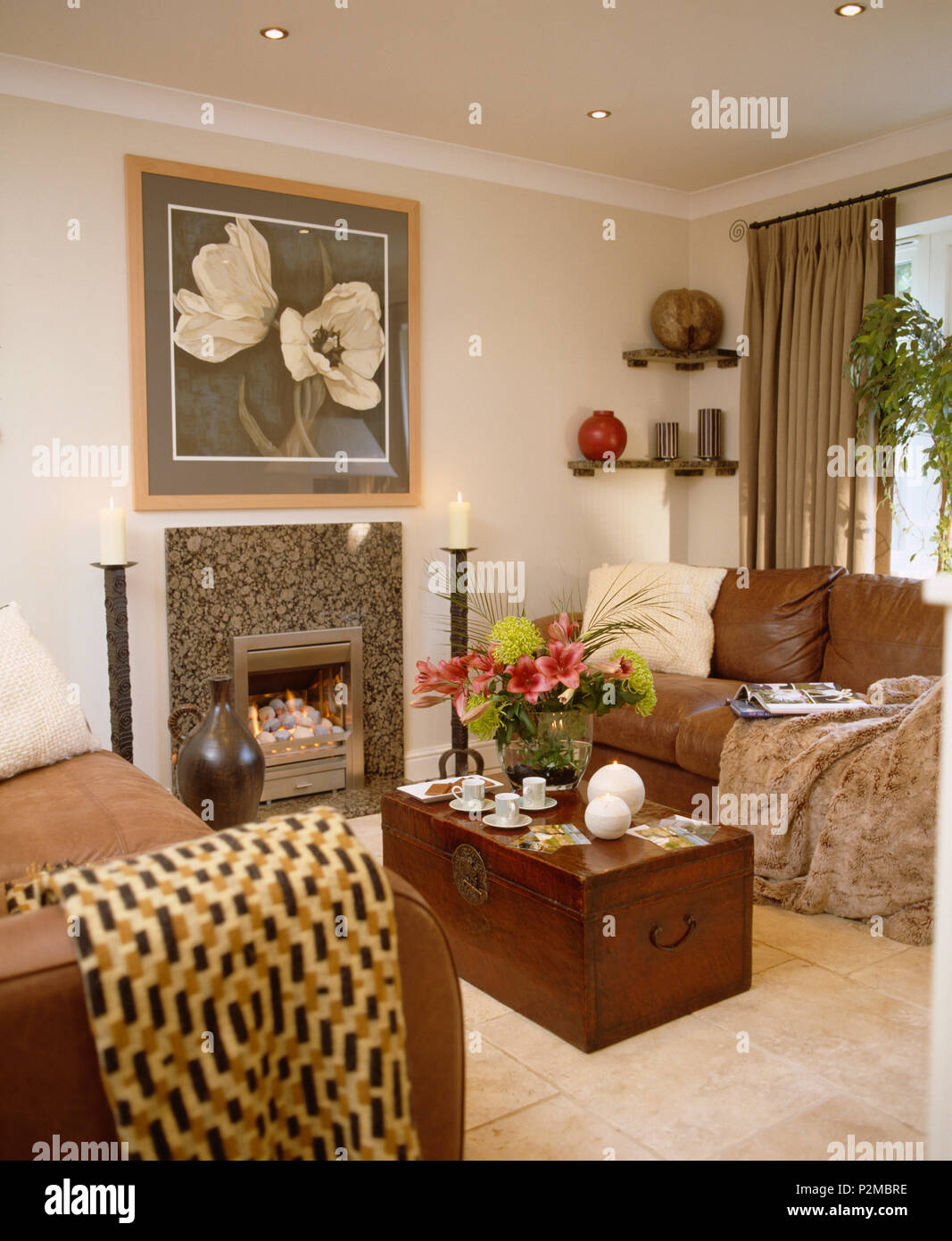 Plaids en laine sur les canapés en cuir brun maison salon avec cheminée au gaz et d'un coffre en bois utilisé comme table basse Banque D'Images