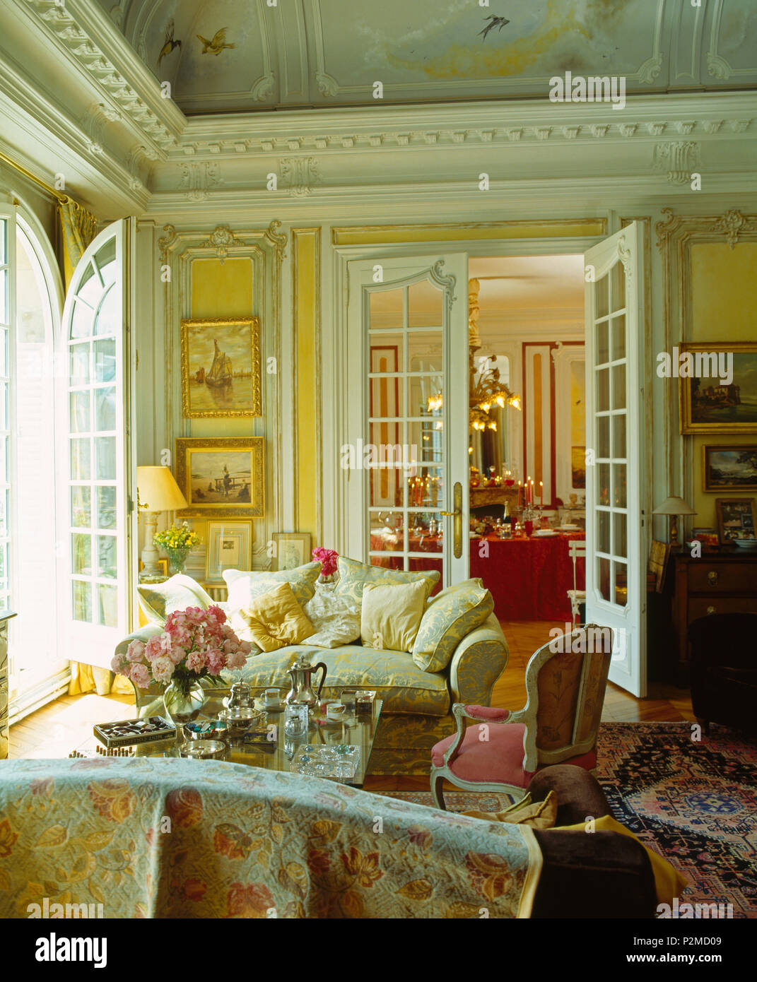 Canapé en face de crème double portes dans l'élégant salon à Paris appartement avec corniches ornées Banque D'Images