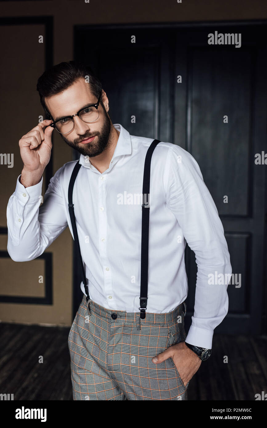 La mode homme posant dans les verres, une chemise blanche et des bretelles  Photo Stock - Alamy