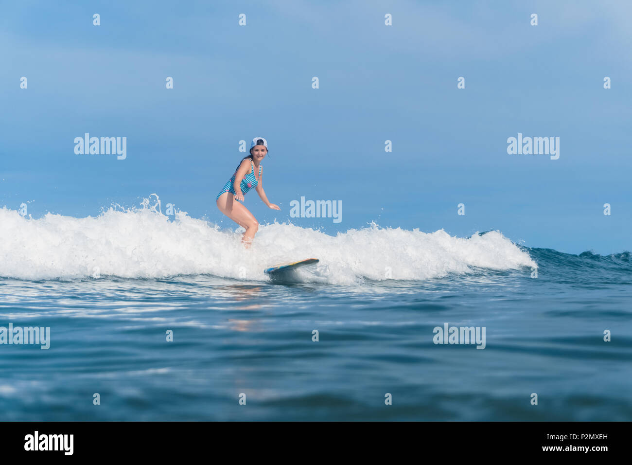 Femme en costume de bain surfing in ocean Banque D'Images