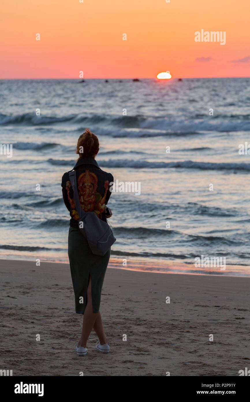 Israël, Tel Aviv, plage, femme regardant le coucher du soleil Banque D'Images