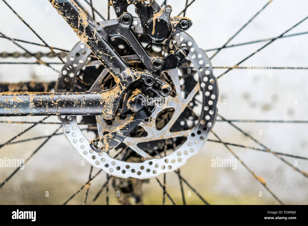 Le rotor du frein hydraulique arrière sur le vélo de montagne. La saleté sur cadre du vélo de montagne après la course dans le mauvais temps Banque D'Images