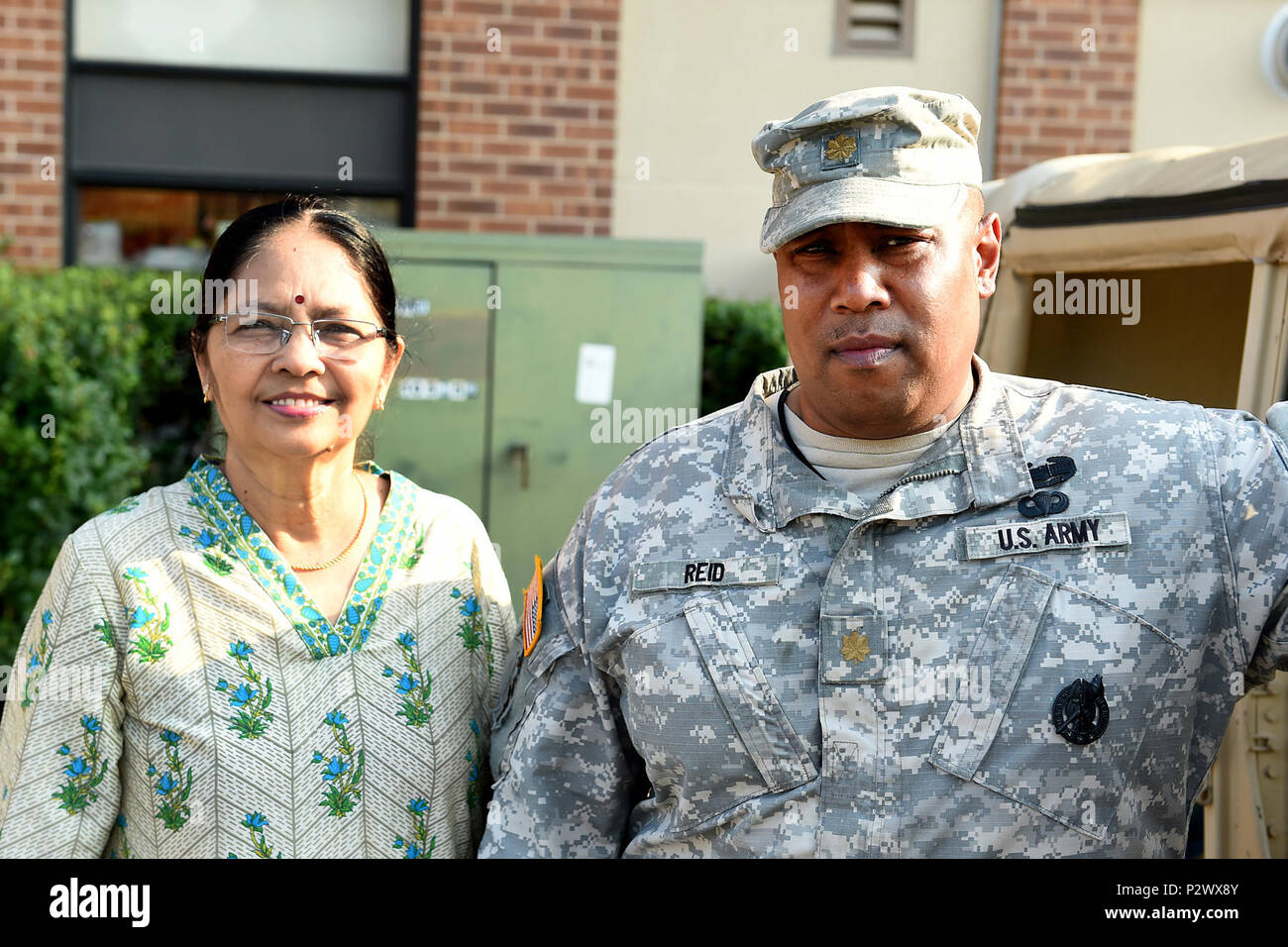 Sukanya Narayan, gauche, l'Inde, s'arrête pour une photo avec l'Armée de terre Le major Lawrence Reid, agent de la gestion des ressources, 85e en charge la commande, à côté d'un Humvee au cours de l'Arlington Heights' Night Out National police communautaire, l'événement le 2 août 2016. Narayan a demandé de prendre une photo avec Reid à envoyer à son frère dans l'Inde qui ont servi dans l'armée de l'Inde. Narayan a dit qu'elle respecte ceux qui portent l'uniforme et de servir leur pays. (U.S. Photo de l'armée par le Sgt. Berogan Aaron/libérés) Banque D'Images