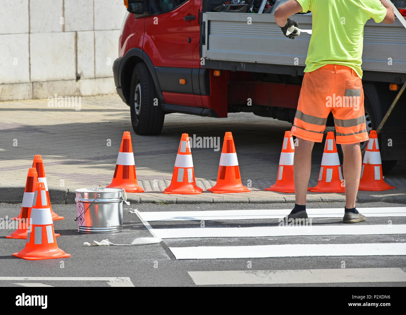 Cônes de circulation sur la rue où l'homme est la peinture du passage pour piétons signe Banque D'Images